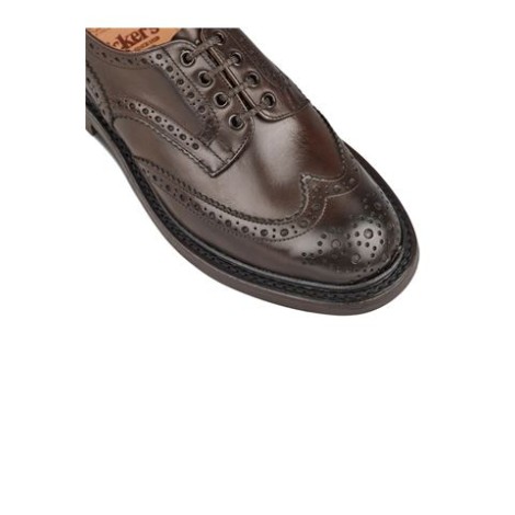 Bourton brogues di Tricker's col. marrone, pelle di vitello, dettaglio traforato, chiusura frontale con lacci, punta smussata, soletta in pelle con logo e suola piatta. 